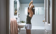 Junge Frau schaut zu Hause in den Spiegel — Stockfoto