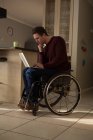 Junger behinderter Mann benutzt Laptop zu Hause — Stockfoto