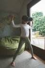 Menina usando fone de ouvido realidade virtual na sala de estar em casa — Fotografia de Stock