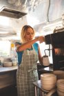 Bellissimo cameriere femminile preparare il caffè in camion cibo — Foto stock