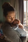 Close-up of mother holding baby at home — Stock Photo