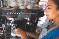 Жінка офіціантка готує каву в харчовій вантажівці — стокове фото