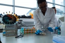 Женщина-ученый использует увеличительное стекло в лаборатории — стоковое фото