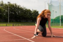 Молодая спортсменка готова бегать по беговой дорожке — стоковое фото