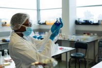 Cientista masculino atento experimentando em laboratório — Fotografia de Stock