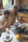 Старшая пара за цифровым планшетом на обеденном столе дома — стоковое фото