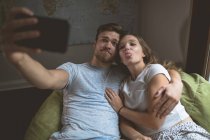 Couple prenant selfie avec téléphone portable à la maison — Photo de stock
