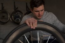Jovem deficiente reparando cadeira de rodas na oficina — Fotografia de Stock