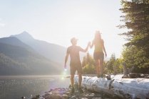 Couple holding hands near riverside in mountains — Stock Photo