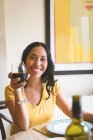 Mulher tendo vinho tinto na mesa de jantar em casa — Fotografia de Stock