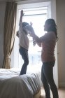Madre aiutare la figlia a indossare un panno a casa — Foto stock