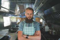 Waiter with arms crossed looking at camera in food truck — Stock Photo