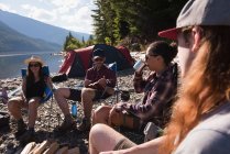 Group of hikers camping near riverside in mountains — Stock Photo