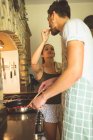 Donna che nutre la colazione all'uomo in cucina a casa — Foto stock