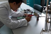 Scienziato di sesso maschile che sperimenta su circuito stampato in laboratorio — Foto stock
