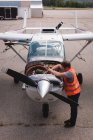 Vista ad alto angolo di ingegnere manutenzione motore aereo vicino hangar — Foto stock