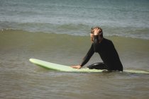 Surfista surfando na água do mar em um dia ensolarado — Fotografia de Stock