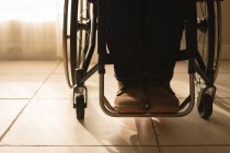 Baixa seção do homem com deficiência em cadeira de rodas em casa — Fotografia de Stock