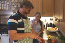 Seniorenpaar schneidet Gemüse in Küche zu Hause — Stockfoto