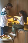Padre e hija lavando verduras en la cocina en casa - foto de stock