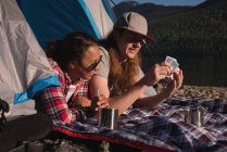 Пара, играющая в карты в палатке — стоковое фото