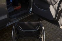 Primer plano de la silla de ruedas y el coche - foto de stock