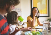 Familie isst zu Hause am Esstisch — Stockfoto