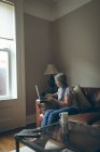 Seniorin benutzt Laptop im heimischen Wohnzimmer — Stockfoto