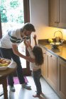 Батько тримає свою дочку на кухні вдома — стокове фото