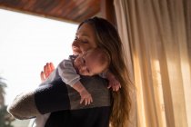Felice madre che tiene il suo bambino a casa — Foto stock