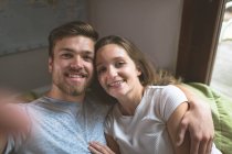 Paar sitzt Arm in Arm zu Hause — Stockfoto