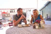 Romantic couple having breakfast in outdoor cafe — Stock Photo