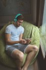 Чоловік слухає музику на цифровому планшеті вдома — стокове фото