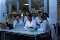 Equipe de cientista usando laptop juntos em laboratório — Fotografia de Stock