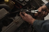 Primo piano del meccanico di sesso maschile che assiste un'auto in garage — Foto stock