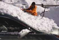 Uomo pulizia neve dal parabrezza auto durante l'inverno — Foto stock