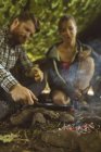 Счастливая пара готовит еду в учебном лагере — стоковое фото