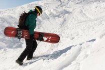 Ski de randonnée avec planche de ski sur une montagne enneigée en hiver — Photo de stock