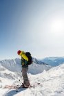 Esquiador em pé em uma montanha nevada durante o inverno — Fotografia de Stock