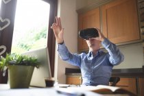 Людина використовує гарнітуру віртуальної реальності на кухні вдома — стокове фото