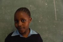Studentessa in piedi vicino alla lavagna in classe a scuola — Foto stock