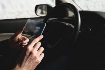 Mann benutzt im Winter digitales Tablet aus Glas im Auto — Stockfoto