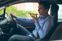 Empresário inteligente falando no telefone celular enquanto dirige um carro — Fotografia de Stock