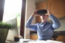 Людина використовує гарнітуру віртуальної реальності на кухні вдома — стокове фото