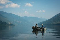 Dos pescadores pescando en el río en un día soleado - foto de stock