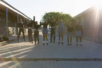 Школьники держатся за руки в школьном городке в солнечный день — стоковое фото