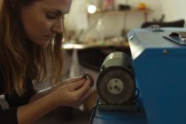 Jewelry designer using sharpening machine in workshop — Stock Photo