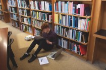 Vue en angle élevé d'un étudiant lisant un livre à la bibliothèque — Photo de stock