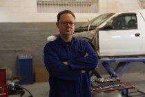 Mechaniker schaut in Garage auf Kamera — Stockfoto