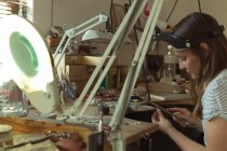 Женщина-дизайнер ювелирных изделий работает в мастерской — стоковое фото